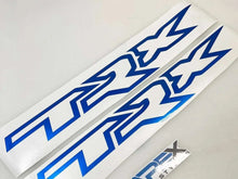 Load image into Gallery viewer, Blue TRX logo windshield banner decals on white background with smaller decal piece, showcasing precision cut vinyl design for truck customization