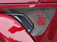 Load image into Gallery viewer, Close-up of a red Jeep Wrangler or Gladiator fender vent with a carbon fiber look decal featuring a red peace sign hand symbol, showcasing the custom Fender Vent Decal product for Jeep vehicles