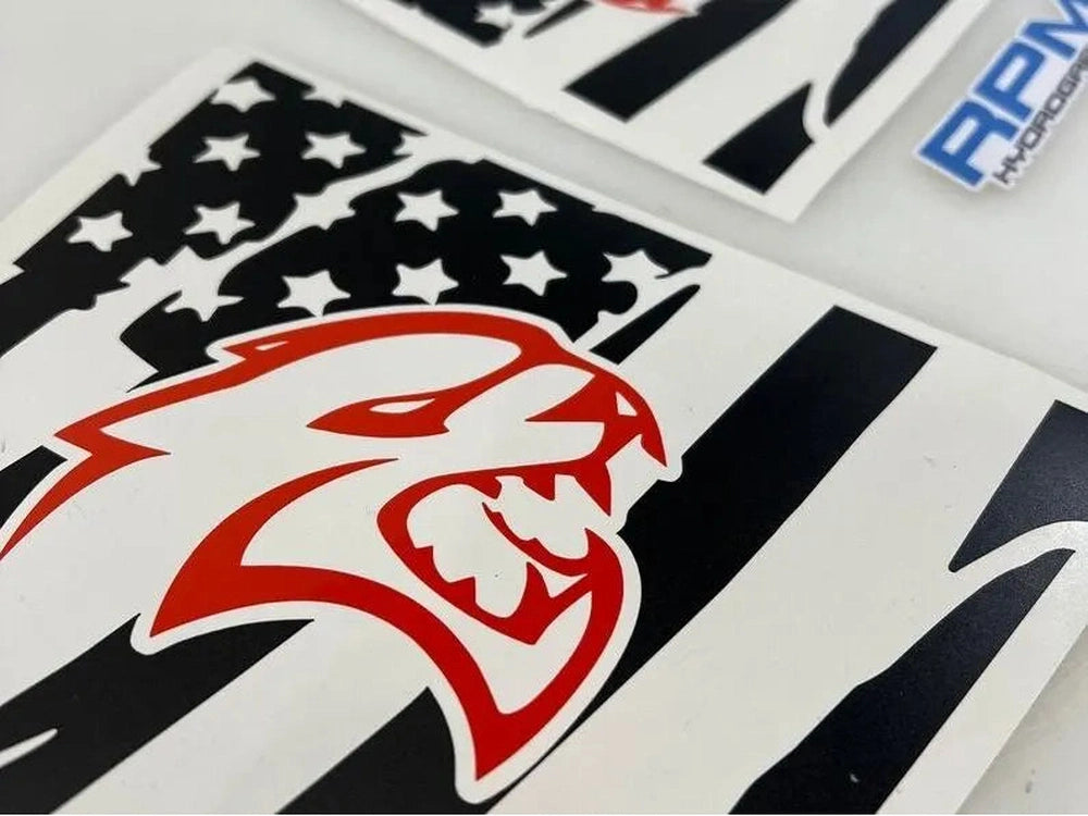 Close-up of Charger Hellcat logo decal with American flag pattern, showcasing red and black designs on white background for custom Dodge Charger quarter window application