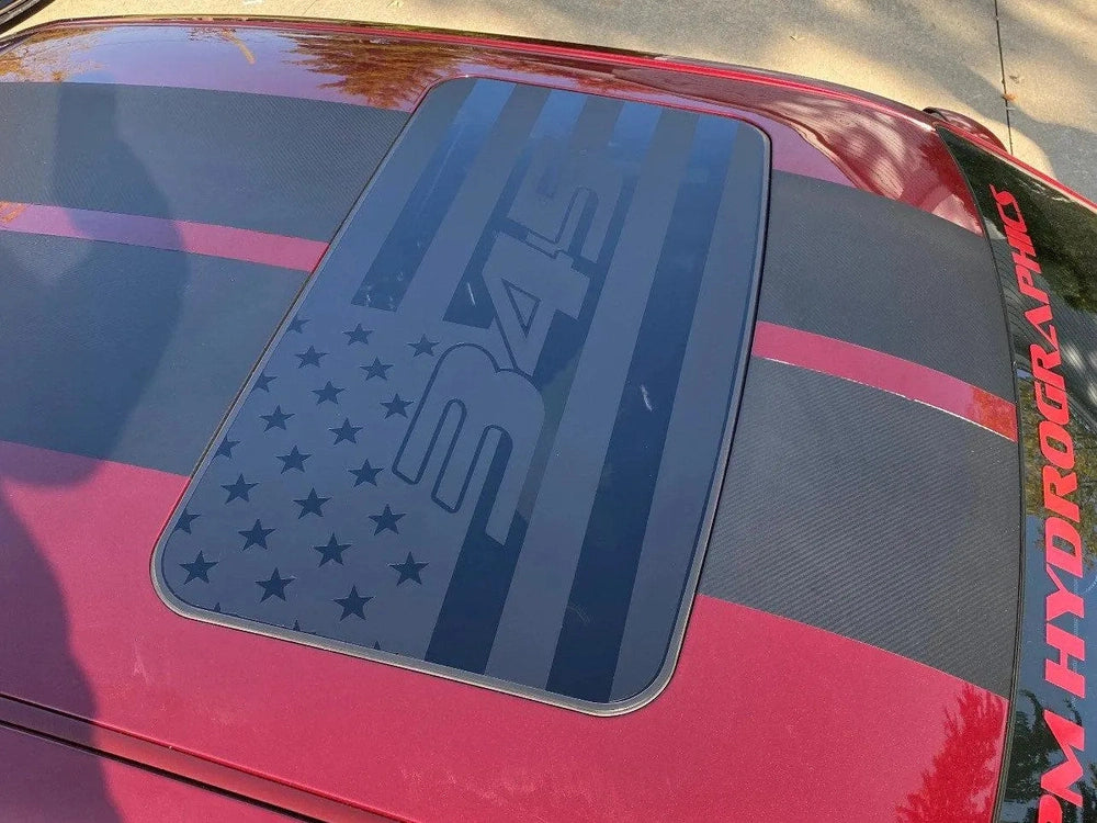 Dodge Challenger sunroof with patriotic R/T decal featuring American flag design in dark blue on red car exterior, showcasing custom vinyl application for muscle car enthusiasts